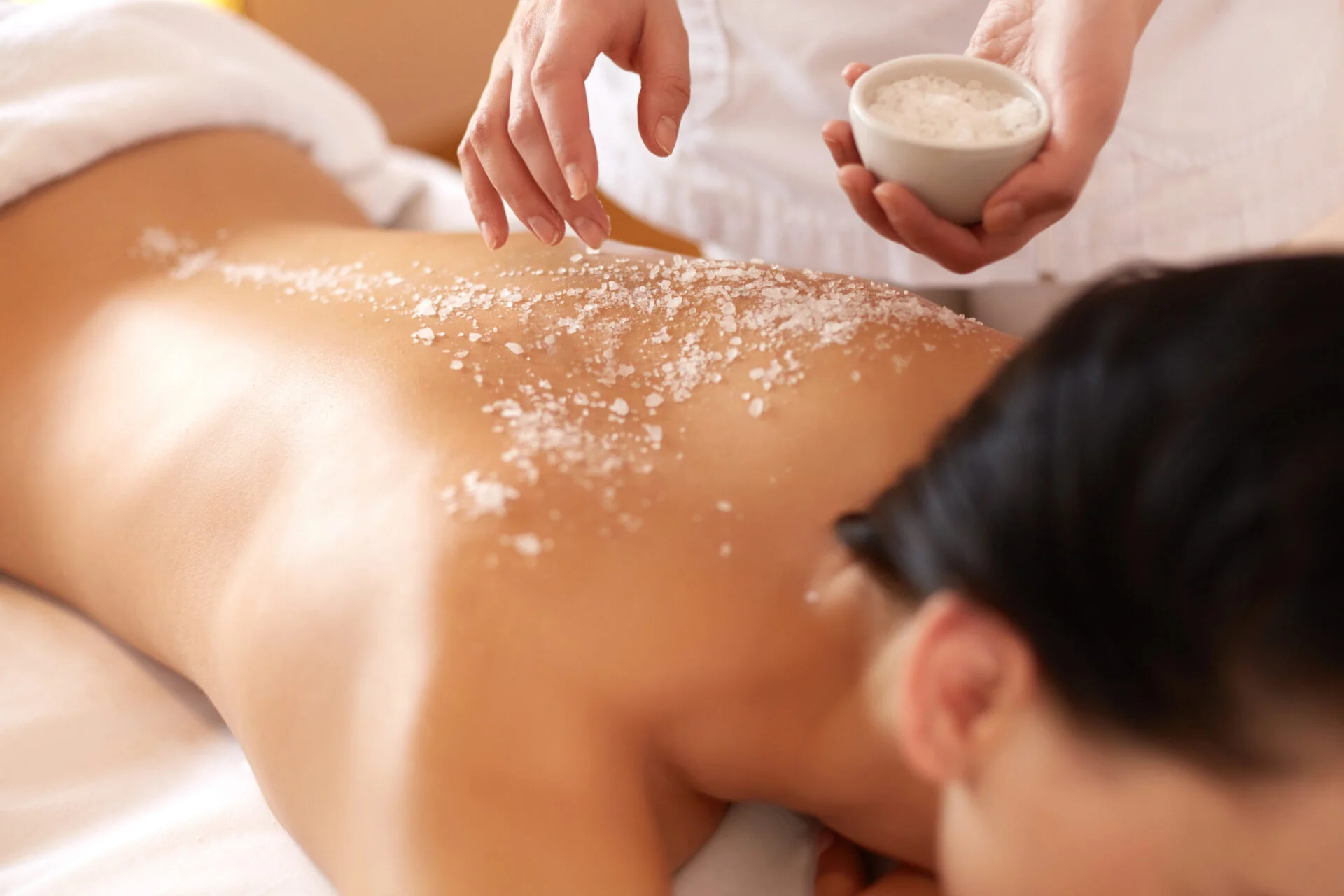 Spa Woman. Brunette Getting a Salt Scrub Beauty Treatment Body polish scrub and mask at White N Bright Spa Thane West